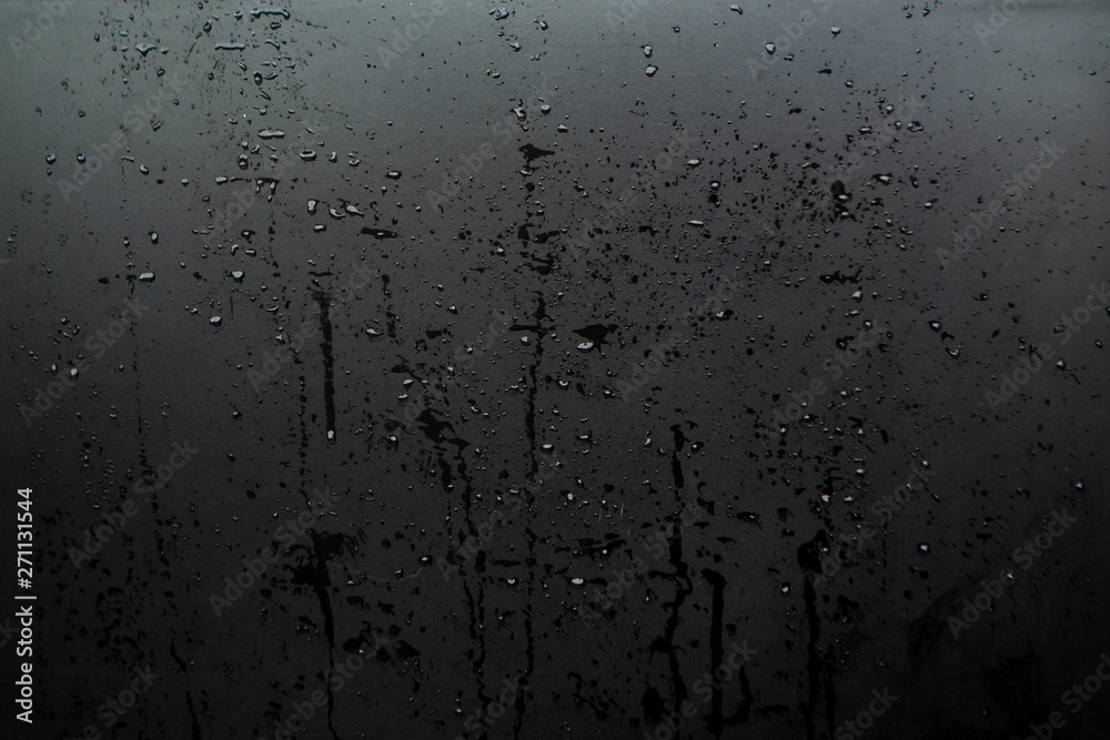 drops of liquid on the glass with drips, the texture is dark, black drops of liquid on the glass with drips, the texture is dark, black