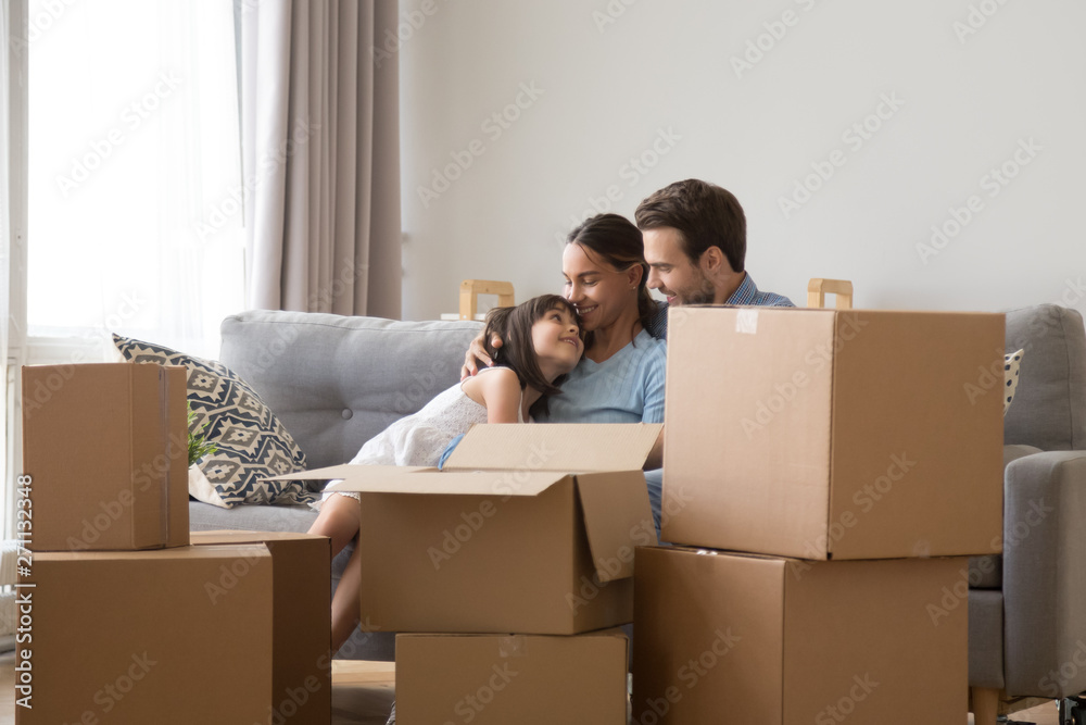 Happy family with daughter relax on couch on moving day Happy family with daughter relax on couch on moving day