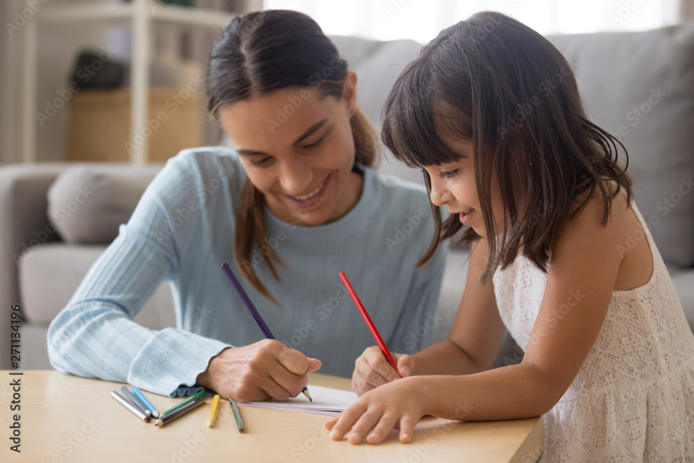 Happy young mom have fun drawing with little daughter Happy young mom have fun drawing with little daughter