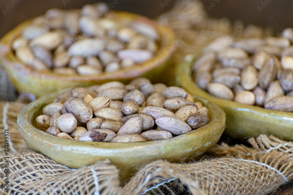 Obraz premium Clay bowls with dried pistachio nuts close up