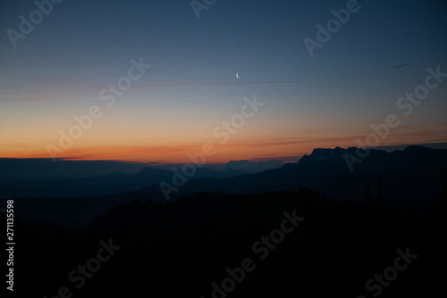 Mond bei Sonnenaufgang mit Bergpanorama