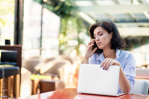 Contemplated young woman in cafe with laptop