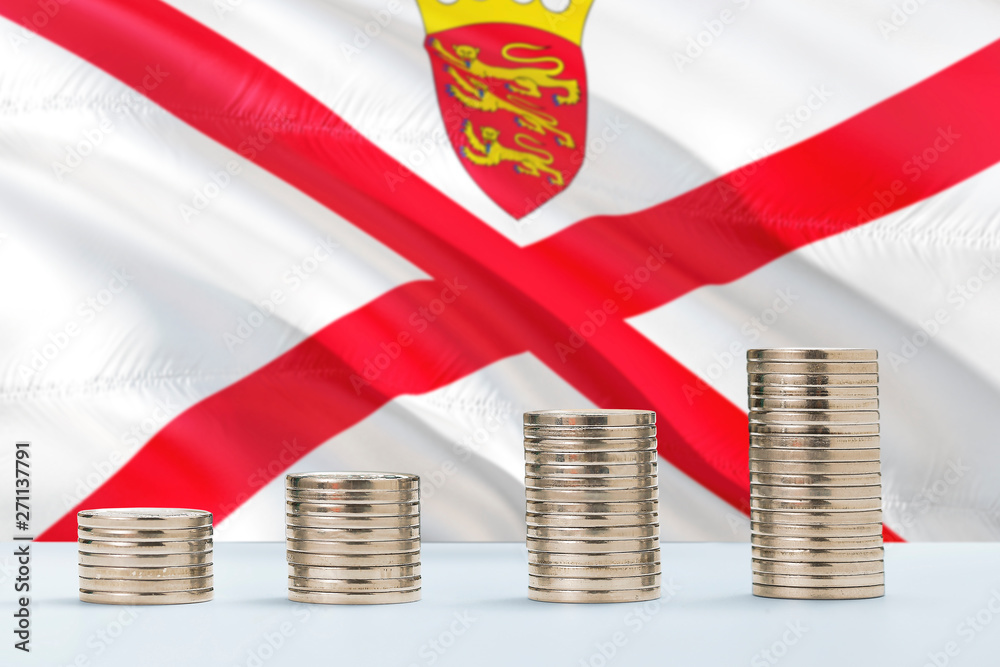 Fototapeta premium Jersey flag waving in the background with rows of coins for finance and business concept. Saving money.