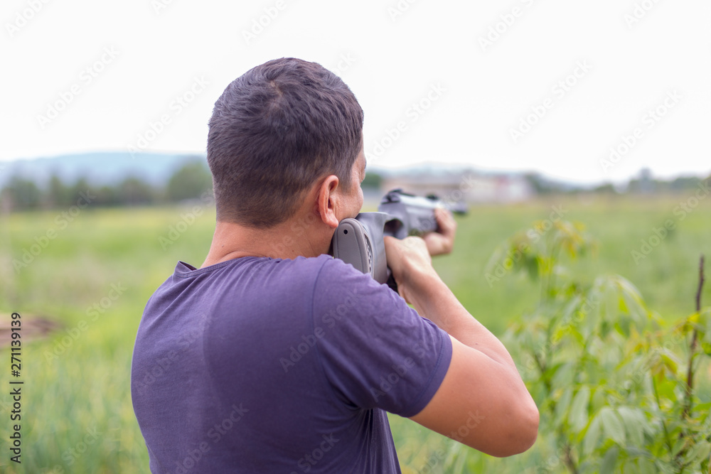 Young man shoots air rifle in nature Young man shoots air rifle in nature