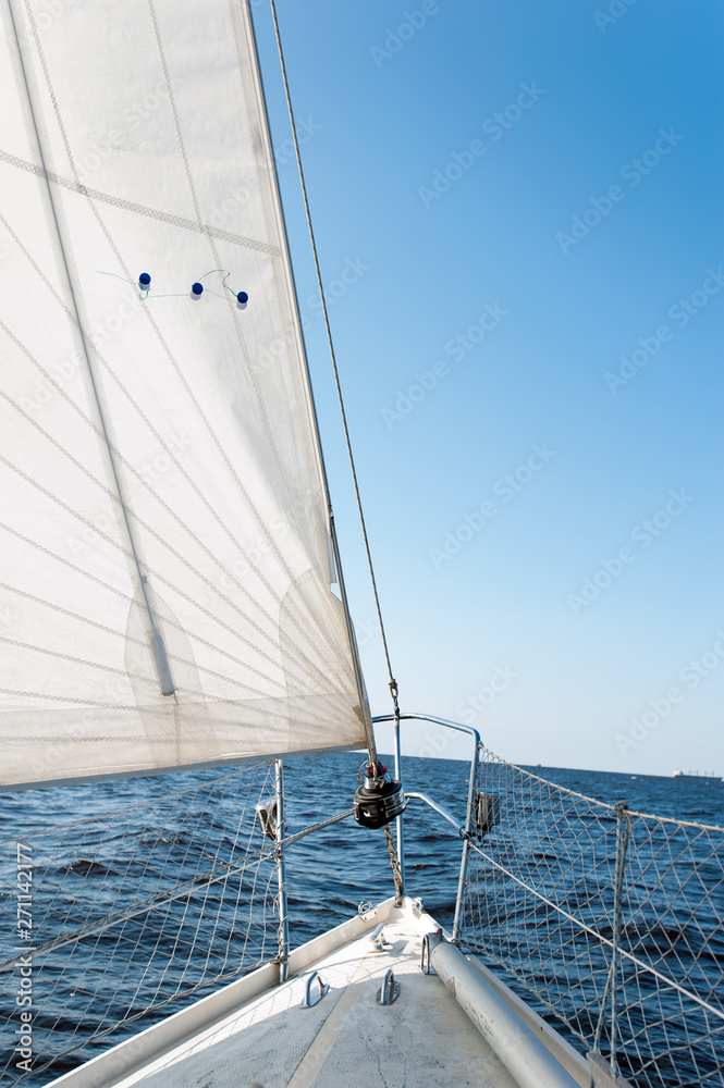 Obraz premium White sailing yacht at a speed swims to shore