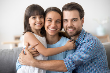 Portrait of happy family with kid hugging posing for picture