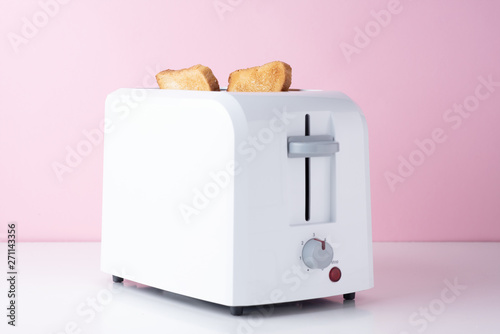 Tablou pe pânză White toaster with  roasted toast bread on pink background, close up