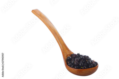 glossy black chokecherry in wooden spoon isolated on white background
