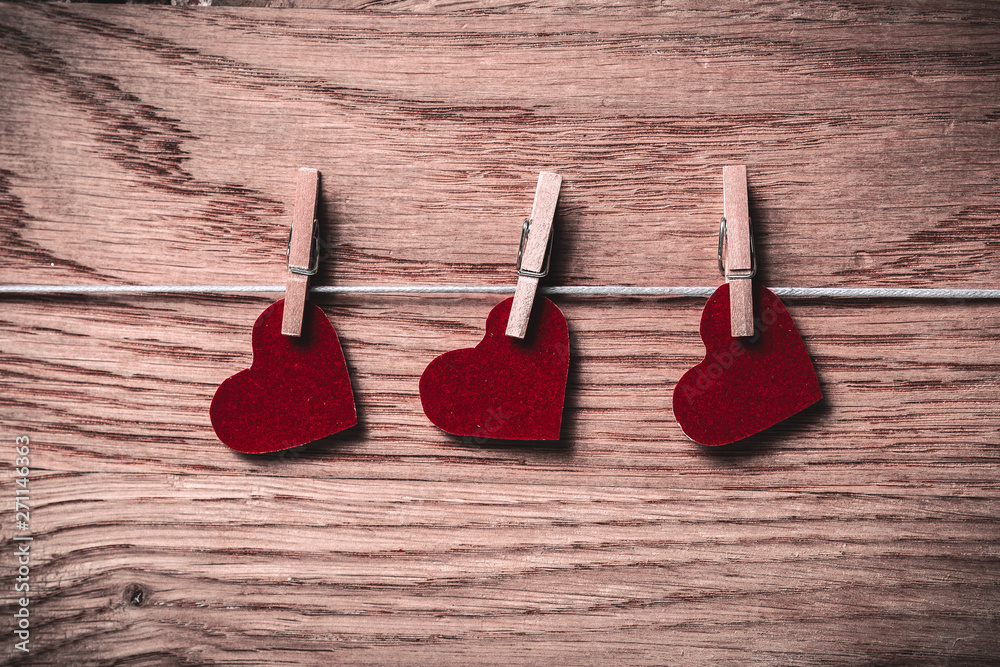red hearts on clothespins on wooden background red hearts on clothespins on wooden background