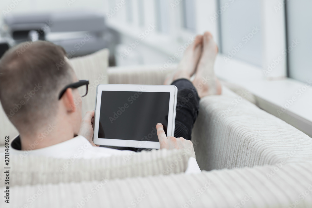 rear view.young man looking at digital tablet screen. rear view.young man looking at digital tablet screen.