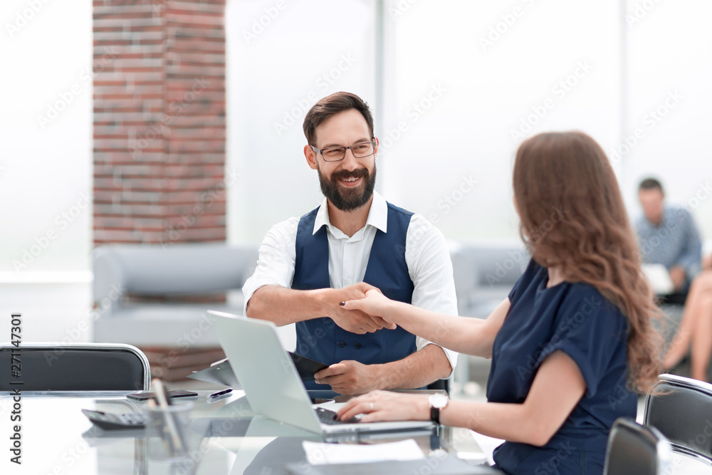 businessman and businesswoman shaking hands over the Desk businessman and businesswoman shaking hands over the Desk