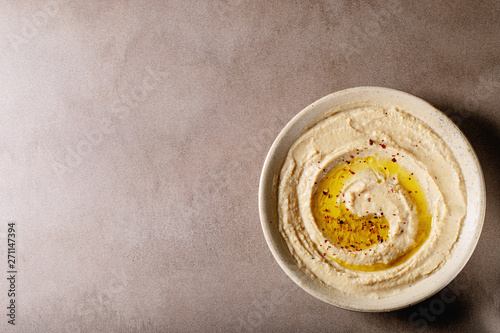 Hummus with olive oil in ceramic bowl