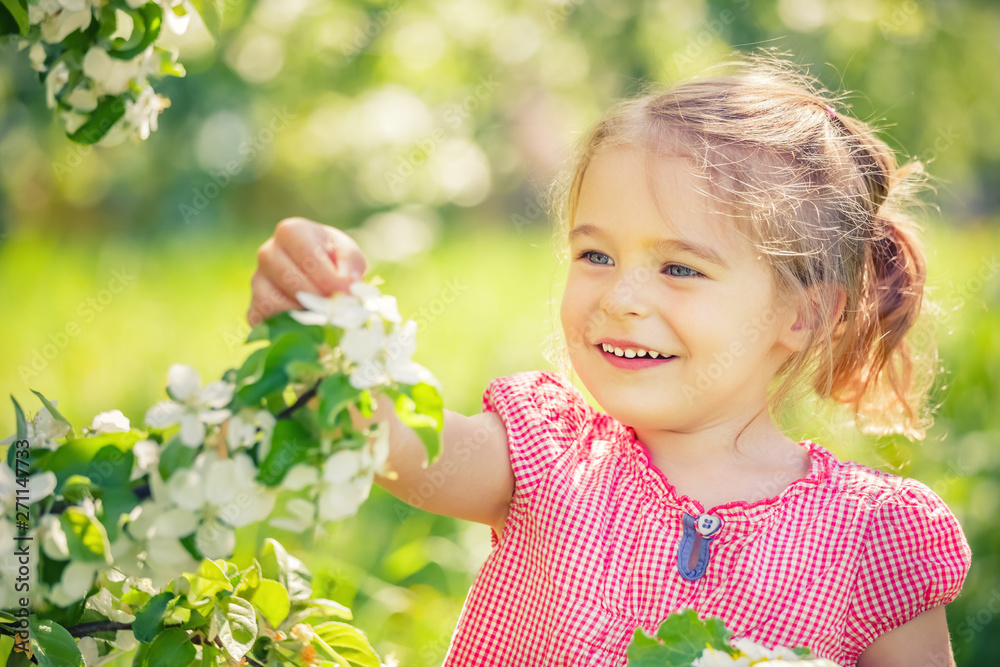 Happy little girl playing in spring apple tree garden Happy little girl playing in spring apple tree garden