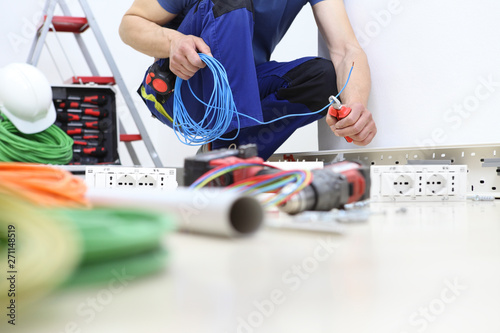 electrician at work with nippers in hand cut the electric cable, install electric circuits, electrical wiring photo