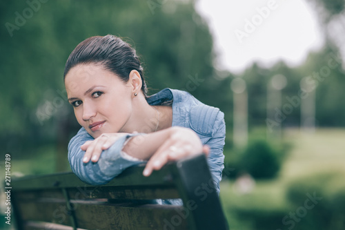 attractive young woman sitting on a Park bench