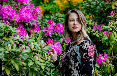 style woman near rhododendron flowers in a grarden in spring time © Masson