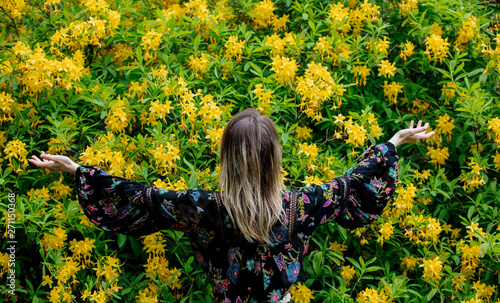 style woman near yellow flowers in a grarden in spring time photo