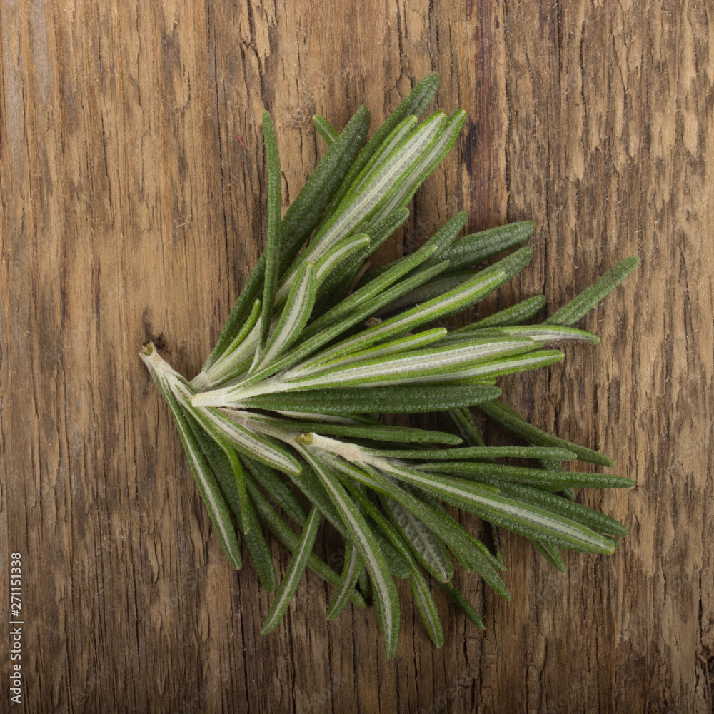 heap of rosemary leaves on wooden background heap of rosemary leaves on wooden background