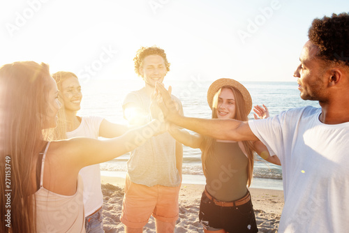 Friends raising their hands on the beach