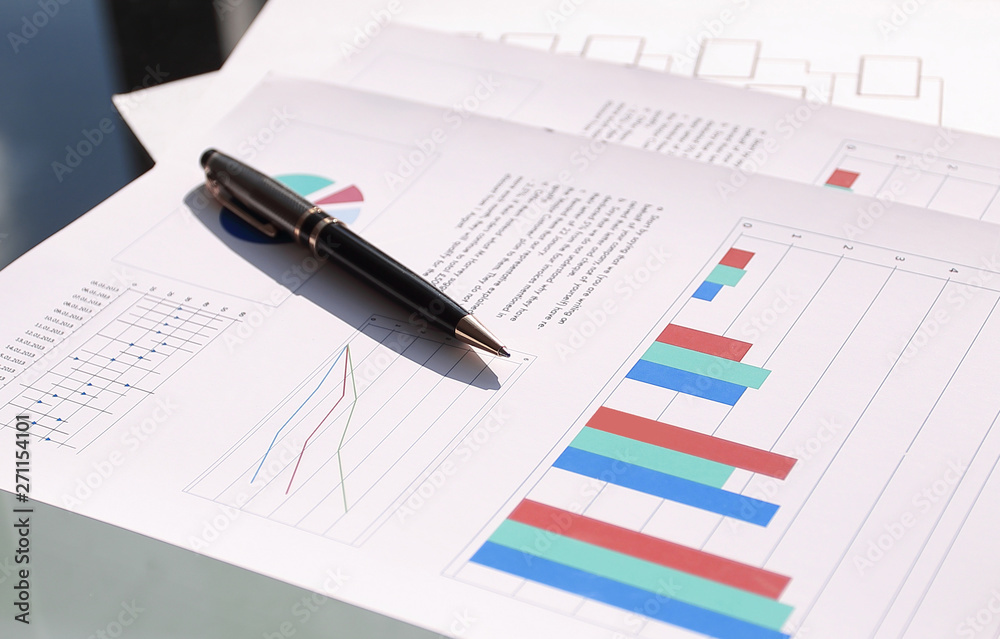 financial chart and pen on glass table in office financial chart and pen on glass table in office