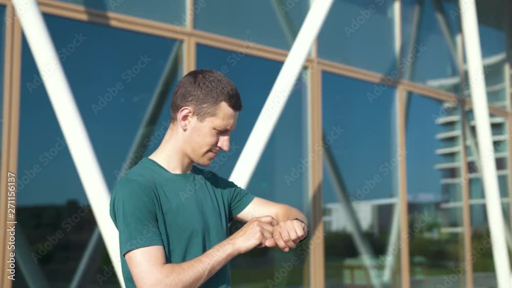 Young sportive man using smart watch while running Young sportive man using smart watch while running