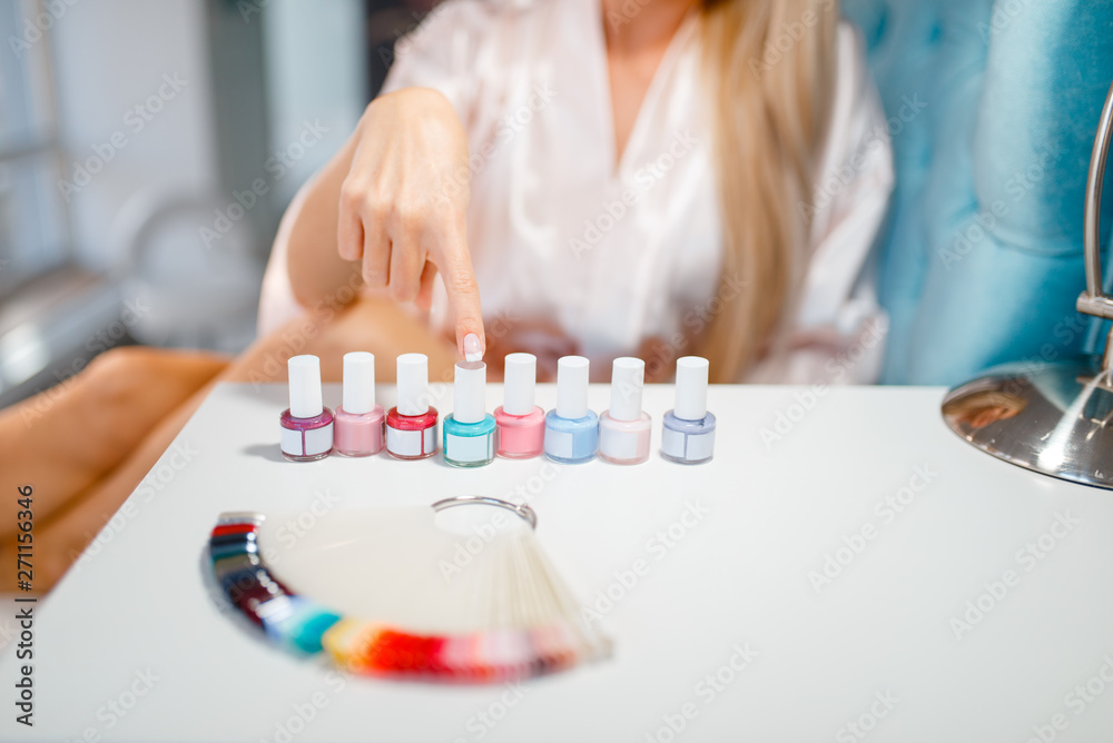 Female customer choosing nail varnish, beauty shop