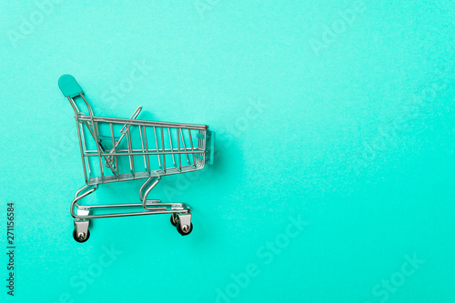 close-up of shopping trolley on green background with some copy space