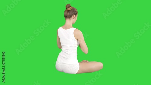 People, yoga and healthy lifestyle Caucasian young blonde woman in lotus pose turning and smiling to camera on a Green Screen, Chroma Key. photo