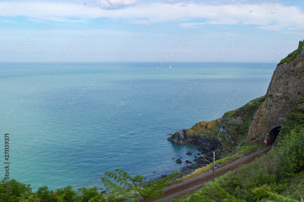 View over Irish sea in Wicklow, Ireland, with rail tunnel through cliff in foreground