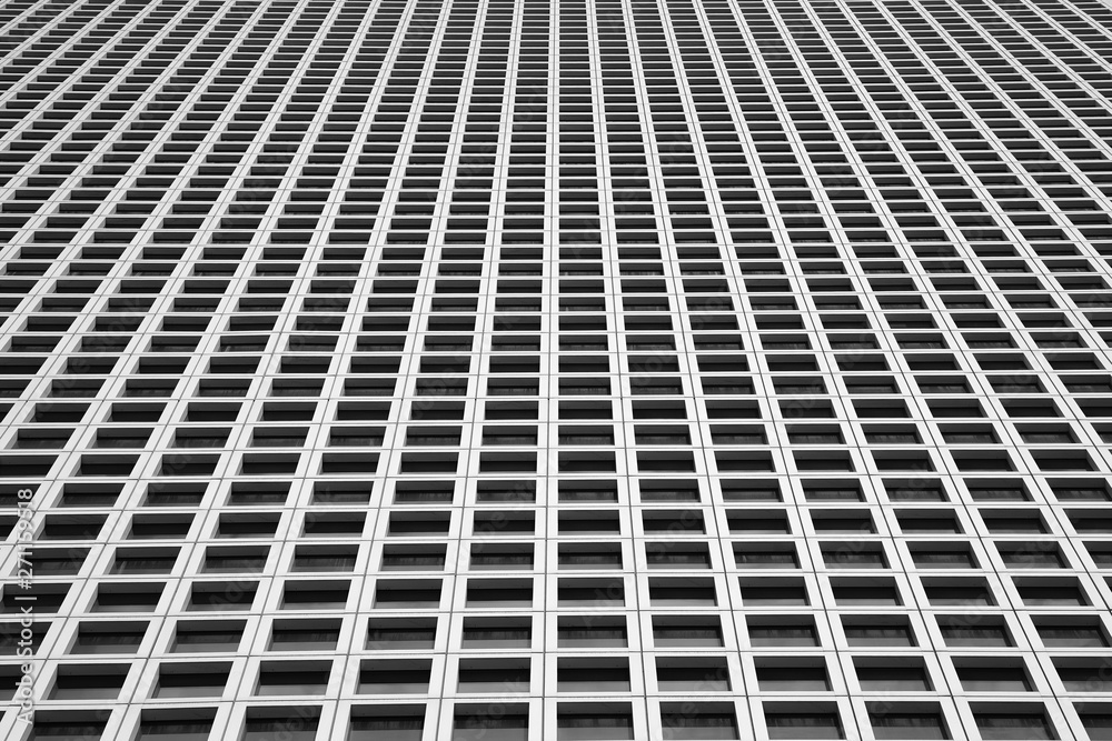 Black and white image of the outgoing perspective of the windows of the facade of a modern building. Glass grey square Windows of modern city business building skyscrape. Texture. Black and white image of the outgoing perspective of the windows of the facade of a modern building. Glass grey square Windows of modern city business building skyscrape. Texture.