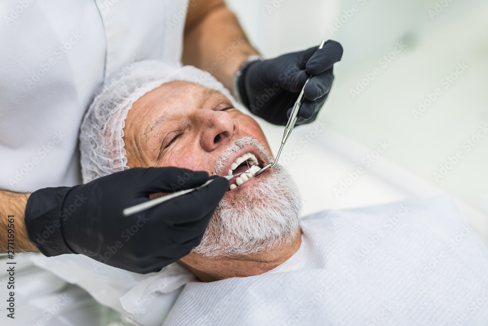 Fototapeta premium Senior man having dental treatment at dentist's office.