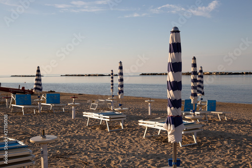 Italian summer on the Adriatic Sea: tyipical italian Riviera Romagnola beach clubs with sunbeds and beach umbrellas with typical vintage colors and look photo