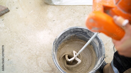 Foto mixing concrete plaster with electric mixer