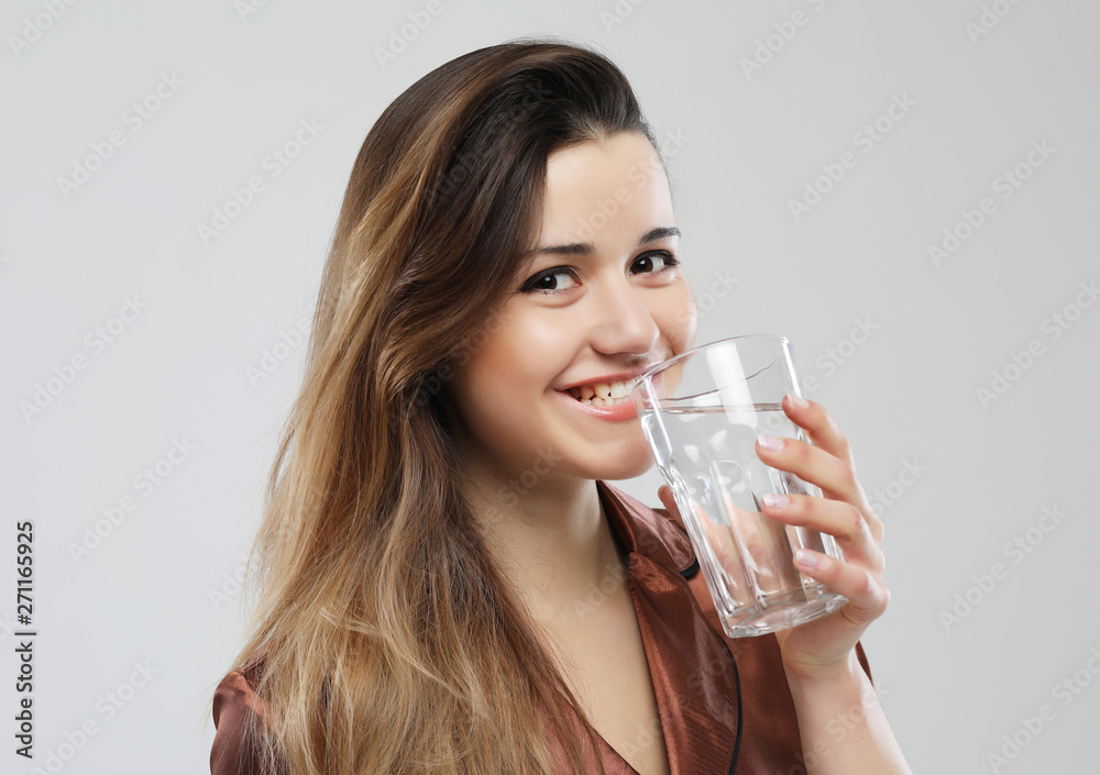 lifestyle and people concept - young woman wearing pajamas holding water glass lifestyle and people concept - young woman wearing pajamas holding water glass