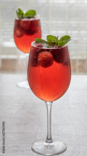 Refreshing drink with strawberries and mint on a table. Perfect for party or hot days. 