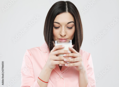 lifestyle and people concept: beautiful girl dressed in pajamas drinking milk