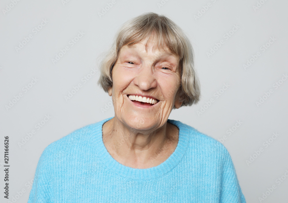 lifestyle,emotion and people concept: funny grandmother posing over grey background lifestyle,emotion and people concept: funny grandmother posing over grey background