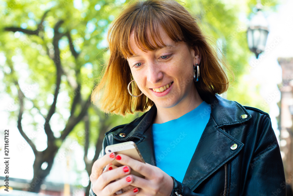 Redhead woman sending message with smartphone. Redhead woman sending message with smartphone.