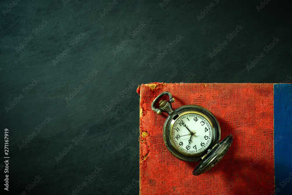 Pocket watch and old book on cement floor. Top view and copy space for text. Concept of time and education. Pocket watch and old book on cement floor. Top view and copy space for text. Concept of time and education.