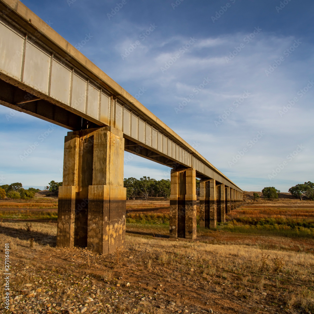 Diminishing perspective view of disused Railway Bridge over Joyces Creek its entry to Lake Cairn Curran on the Moolort Plains near Newstead, Victoria, Australia Diminishing perspective view of disused Railway Bridge over Joyces Creek its entry to Lake Cairn Curran on the Moolort Plains near Newstead, Victoria, Australia