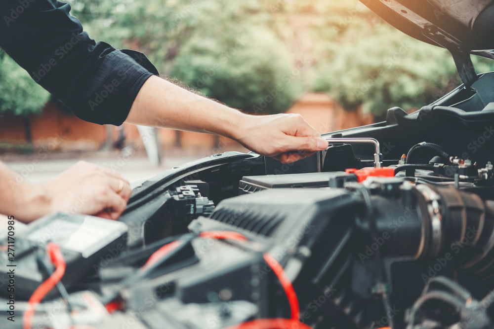 Auto mechanic working in garage Technician Hands of car mechanic working in auto repair Service and Maintenance check car battery. Auto mechanic working in garage Technician Hands of car mechanic working in auto repair Service and Maintenance check car battery.