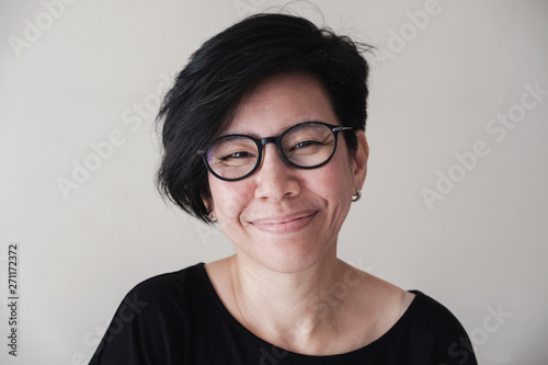 Portrait of happy and healthy natural looking middle aged Asian woman wearing glasses and smiling at camera, women's day, stop Asian hate concept 