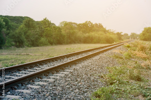 Fotografia The railroad through the countryside in the morning and the big trees in the sid