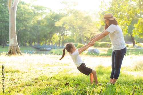 Fototapeta Naklejka Na Ścianę i Meble -  Young asian mother and little daughter playing the park with fun and happiness, family enjoy and relax and leisure together, mom and children smiling laughing in summer day.