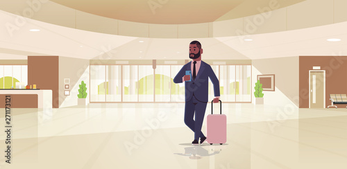 businessman with luggage modern reception area african american business man holding suitcase guy standing in lobby contemporary hotel hall interior flat horizontal full length