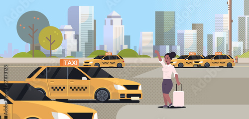 businesswoman catching taxi on street african american business woman with luggage stopping yellow cab city transportation service concept cityscape background full length flat horizontal