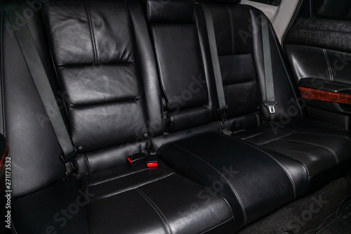 Сlose-up of the car   interior: black leather rear seats and seat belts . © Виталий Сова