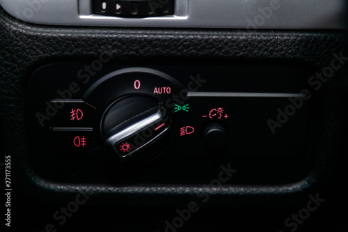 Сlose-up of the car black interior: dashboard,headlight adjustment buttons and other.