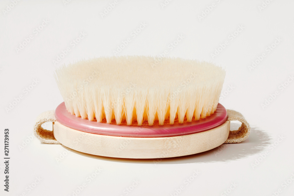 Dry body massage brush on white background at sunny day. Tool for smooth and soft skin. Dry body massage brush on white background at sunny day. Tool for smooth and soft skin.
