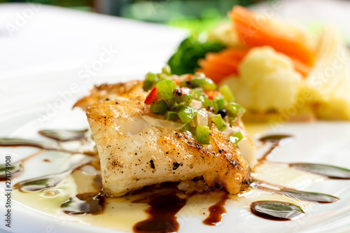 grilled snapper fish steak with vagetable : Healthy lunch grilled snapper fish fillet with fresh salad close-up on a white plate.